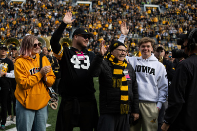 Dr. Morgan Jones and his family on the field during Homecoming Pregame performance in Kinnick Stadium