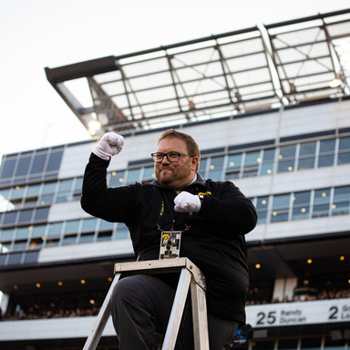 Dr. Eric Bush conducting the HMB From the ladder on the field in Kinnick Stadium