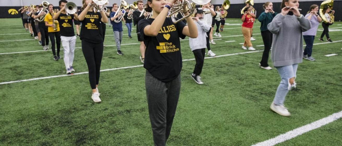 Mellophone players rehearsing in the HTRC, wearing shirts that read "Mellies love the Brick Kitchen"